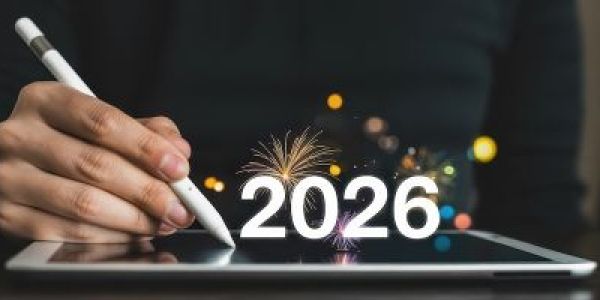 Person using a digital pen to write 2026 on a tablet.